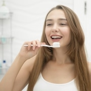 Portrait of a young smiling girl cleaning her teeth