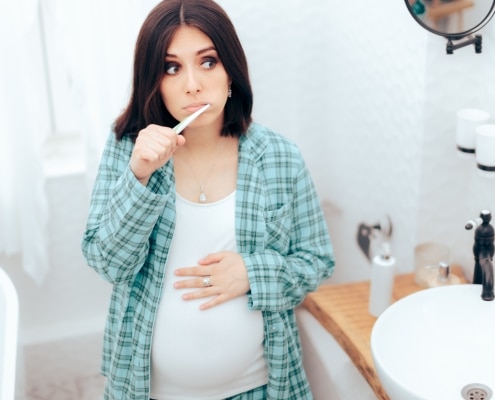 Pregnant Woman Brushing Her Teeth in the Bathroom